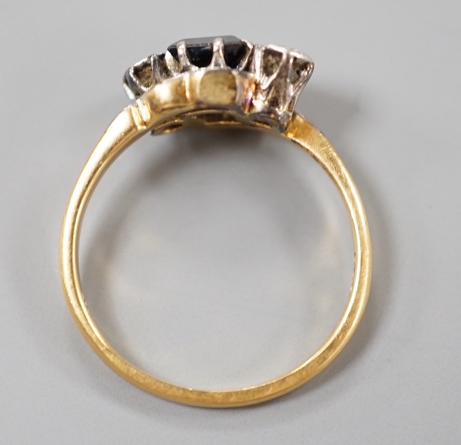 A 1960's 18ct gold, sapphire and diamond set three stone crossover ring, size M, gross weight 3 grams.